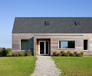 Фасад из деревянного сайдинга и крыша выполнены в одном цвете, но крыша более темного оттенка
